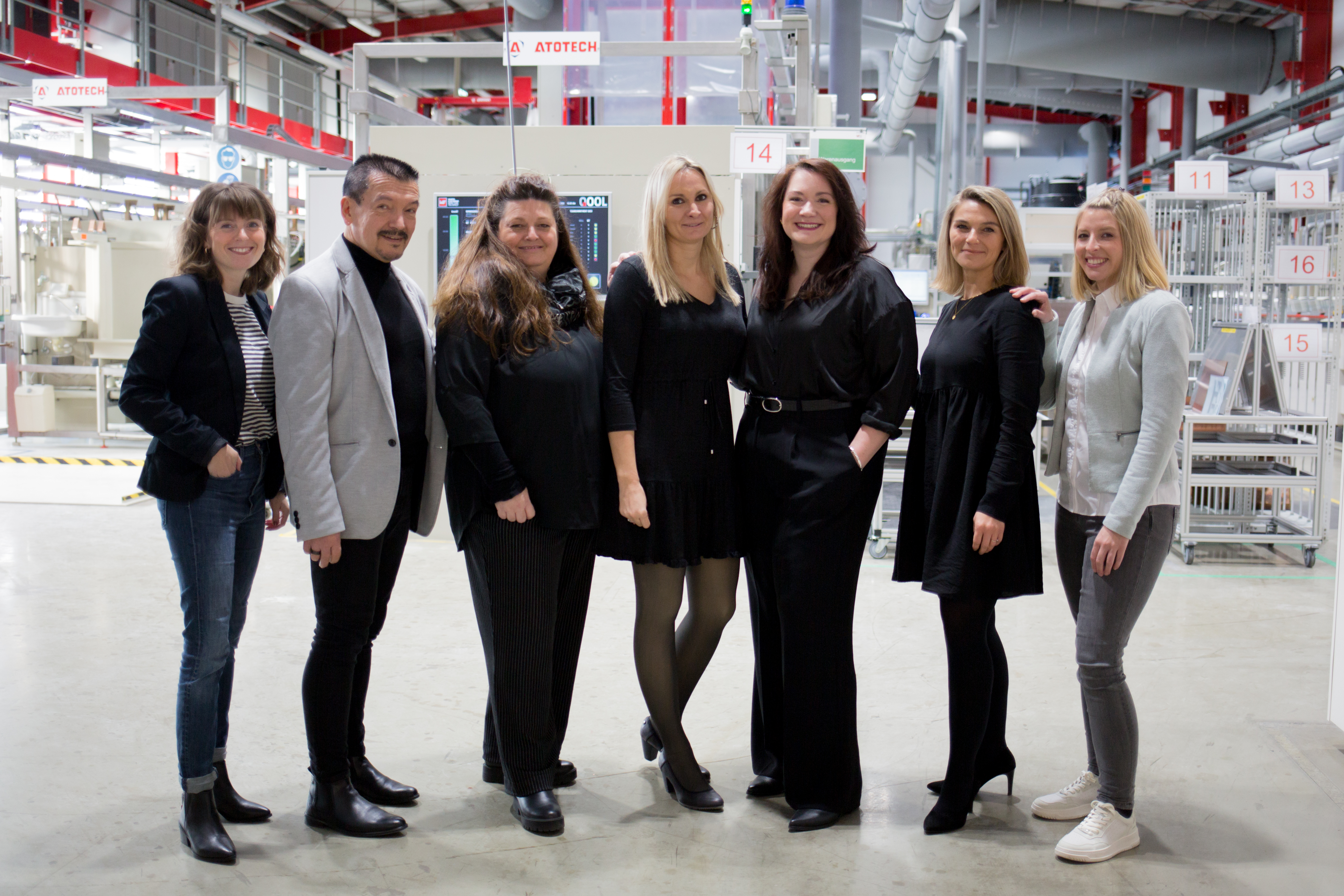 WEdirekt Team Eight persons standing in a row in front of PCB production